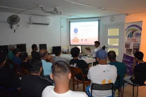 A full theory class watching a Spanish DGT practice question projected on screen, asking where a no-parking sign applies. The instructor is explaining it to the room.