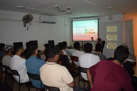 An instructor standing at the screen explaining the priority order of traffic signals to a seated theory class.